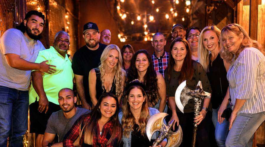 Happy group of friends posing together at Extreme Axe Throwing in Hollywood Florida, enjoying a fun and social indoor activity