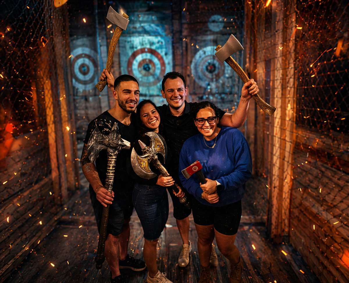 Group of friends smiling and holding axes at an indoor axe throwing venue in Hollywood Florida