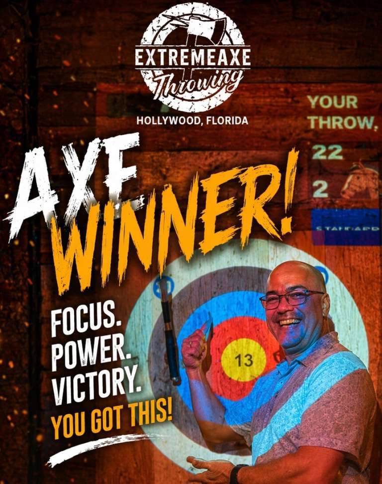 Man celebrating a successful axe throw while pointing at the bullseye target at Extreme Axe Throwing Hollywood Florida