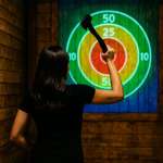 Woman throwing an axe at an interactive projected target at Extreme Axe Throwing in Hollywood, FL