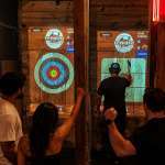 Adults enjoying indoor axe throwing nightlife activity at Extreme Axe Throwing Hollywood in Florida