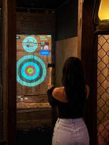 Woman enjoying indoor axe throwing at Extreme Axe Throwing Hollywood near Fort Lauderdale