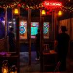 Bachelor party group enjoying indoor axe throwing near Fort Lauderdale in a cozy nightlife atmosphere