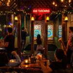 Couples and friends enjoying late night indoor axe throwing near Hollywood Beach