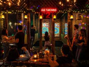 Couples and friends enjoying late night indoor axe throwing near Hollywood Beach