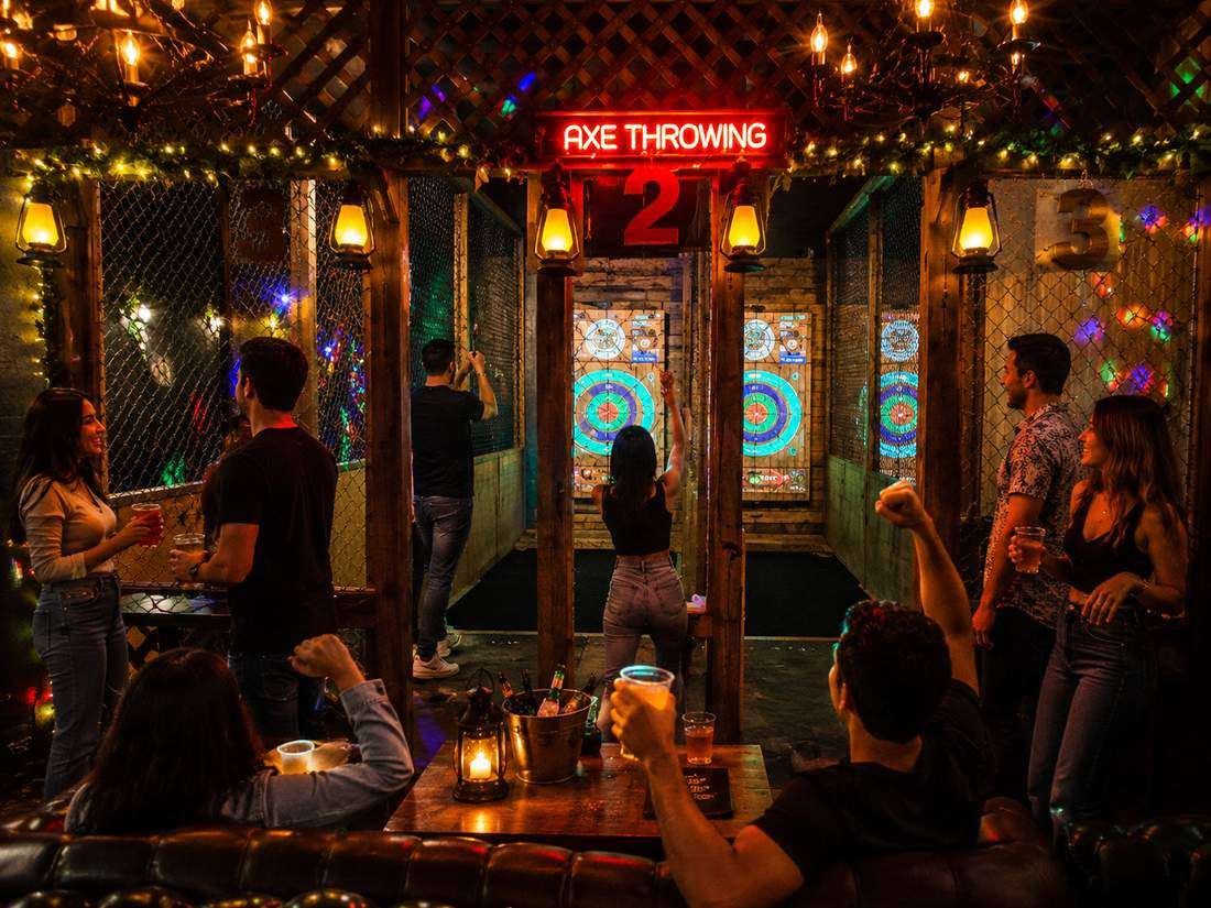 Couples and friends enjoying late night indoor axe throwing near Hollywood Beach
